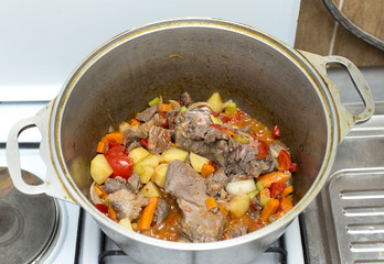 gas stove, food in a cast-iron pan