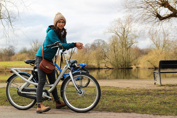 A young woman with a bicycle in the park