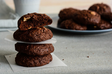 Chocolate cookies for breakfast with hazelnut and a glass of milk on a gray table.