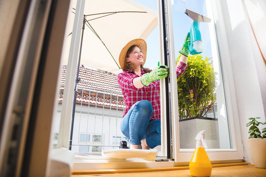 Fr&uuml;hjahrsputz (frau putzt fenster in eigenem zuhause )