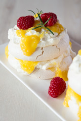 White pavlova cake with mango and raspberries