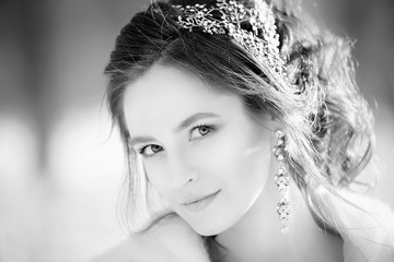 Portrait of bride with wedding make-up and hairstyle on a sunny winter day close-up. Black and white image.