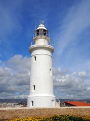 the famous historic white lighthouse in Paphos Cyprus with bright blue sky and beautiful clouds
