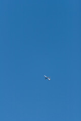 A passenger airplane in the cloudless spring April sky at sunset