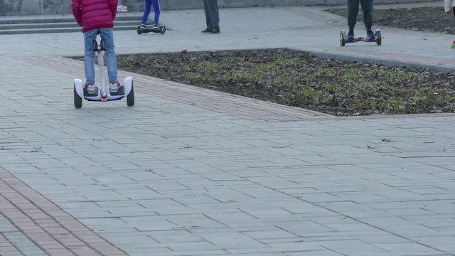 Kiev, Ukraine - APR 8, 2018: Young Girls Friends Legs In Jeans In Park Enjoy Riding Segway Gyroboards.