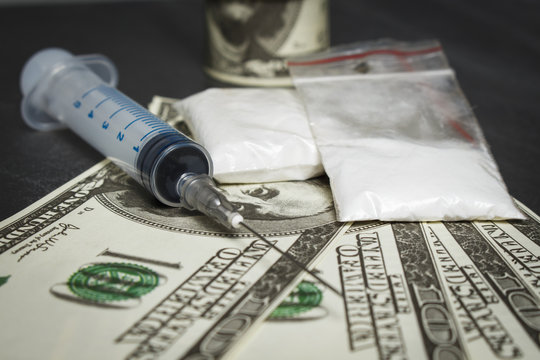 Syringe and plastic bags with drugs near a pile of dollars Stock Photo |  Adobe Stock