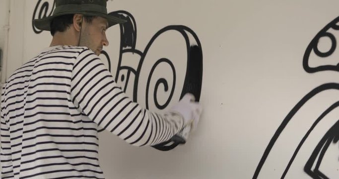 Graffiti artist paint spraying the wall, urban outdoors street art concept