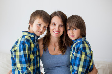 Portrait of beautiful pregnant mother, hugging with love and tenderness her children