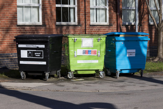 Three coloured recycling dumpsters