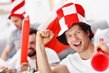 Fototapeta Happy male friends cheering and watching sports on tv obraz