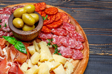 Meat and cheese plate with salami sausage, chorizo, parma and parmesan cheese