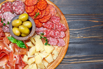 Meat and cheese plate with salami sausage, chorizo, parma and parmesan cheese