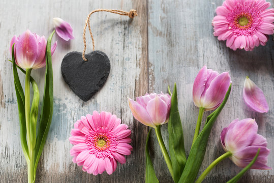 Pink flowers with a heart on vintage planks