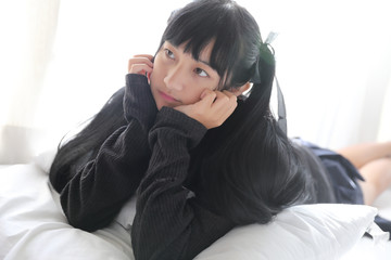 Young pretty girl wearing black cotton sweatshirt on bedroom white tone