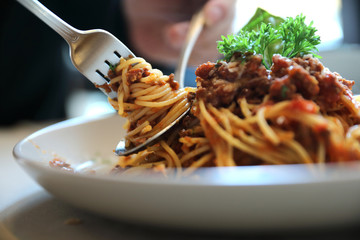spaghetti Bolognese with minced beef and tomato sauce garnished with parmesan cheese and basil ,...