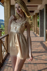 Young beautiful blonde woman in a beautiful dress on a Russian wooden staircase
