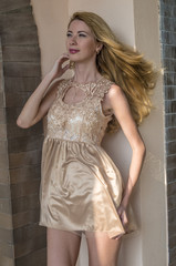 Young beautiful blonde woman in a beautiful dress on a Russian wooden staircase

