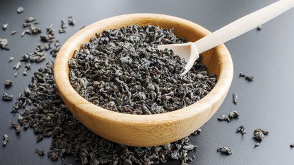 black tea leaves in a wooden bowl