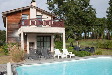 luxury villa home in summer holiday resort with swimming pool and sun chairs
