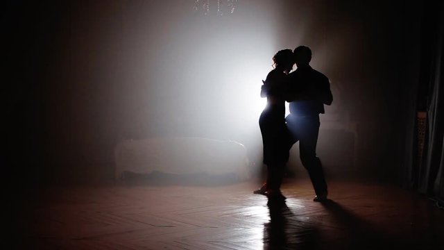 Couple dancing latin dance in the fog