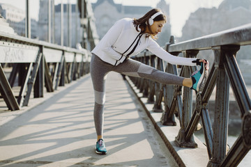 Young sportswoman stretching and preparing to run