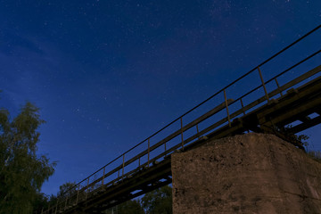 Night sky with many stars before sunrise. View from under the bridge.