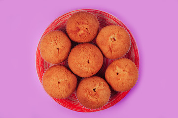 cupcakes in a round plate on a purple background, top view