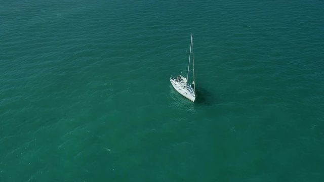 Flying Around White Anchored Yacht In Blue Turquoise Sea. Aerial cinematic view