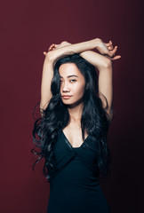 Beautiful asian woman in black dress posing in studio