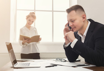 Male and female managers working on financial papers at modern office interior