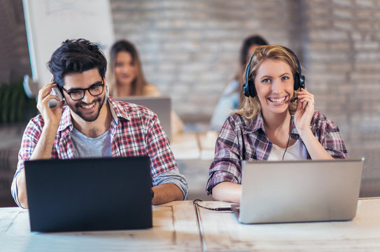 Portrait of happy smiling customer support phone operator at workplace.