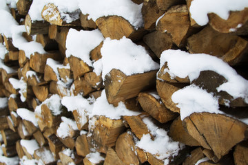 Firewood neatly folded covered with snow for the stove and fireplace