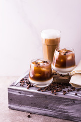 Iced coffee in glasses with milk. Black background