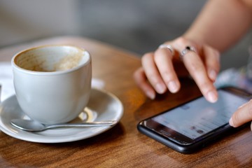 People using smartphone and drinking coffee cup hot