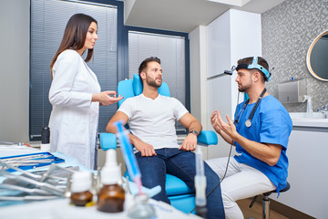 Obraz premium A doctor and his assistant consulting with the patient in the hospital room.