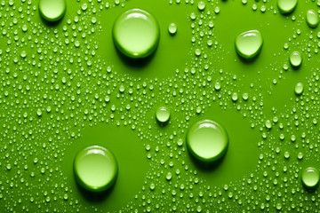 Small and large drops of water on a colored background. Abstract liquid sprays