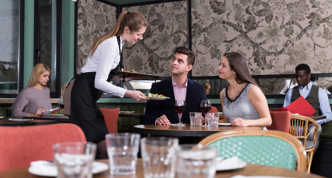 Waitress serving young couple