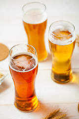 glasses of assorted beer with wheat on a wooden table background for tasting