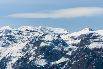 Picturesque view of the high mountain peaks covered in snow with white clouds on the blue sky on the background, Dolomites, Trentino, Italy