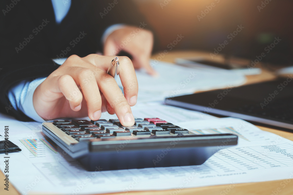 Poster close up hand accountant using calculator with laptop. concept saving finance and accounting