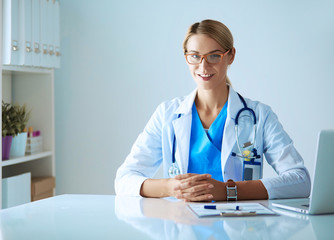 Doctor and patient couple are discussing something,sitting on the desk.