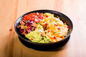 nachos with melted cheese, guacamole and red beans