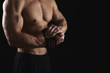Naklejka premium Athletic boxer wrapping hands with boxing bandage