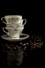 Fototapeta premium Tazzine e chicchi di caffè su fondo nero