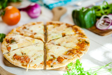 closeup fresh homemade traditional cheese italian pizza on wooden table with ingredients around. wallpaper for pizzeria and cooking food concept