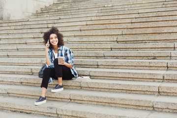 Young woman talking on phone and smiling outdoors