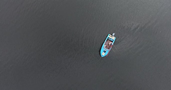 Top view of a boat with a fisherman who catches fish for fishing rod