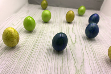 Happy Easter spring background. A mug of coffee in a woman's hand on a white background of decorated colorful Easter eggs and chocolate. Creative instagram flat lay. Top view. Spring mood.