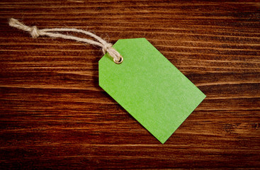 Green tag on wooden background