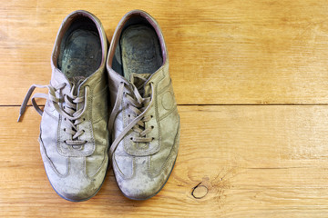 vintage dirty low shoes isolated on a wooden background